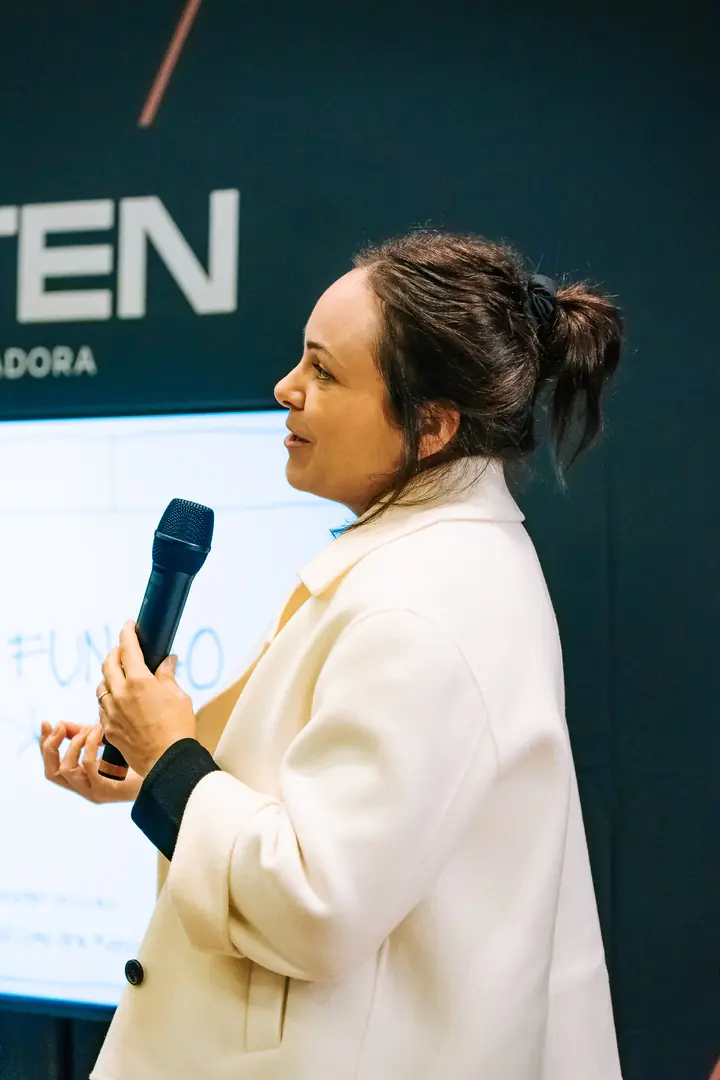 Arquiteta fala ao microfone em encontro do Auten Talks.